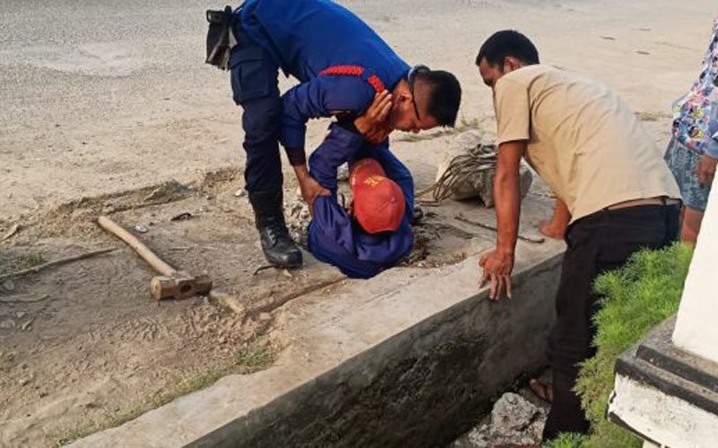 Petugas Damkar Plered Rela Masuk Saluran Air Trotoar Demi Ambil Handphone Milik Warga