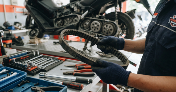 Kapan Waktu Ganti V-Belt Motor Matic? Kenali Tanda & Patokannya Mekanik sedang memeriksa kondisi v-belt motor matic yang retak dan aus di bengkel.